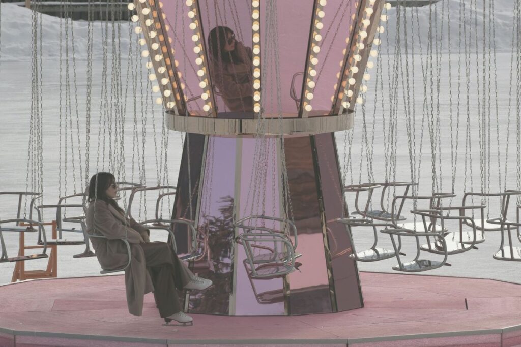 Gedankenkarussell stoppen Frau sitzt ruhig und nachdenklich in einem stillstehenden Kettenkarussell